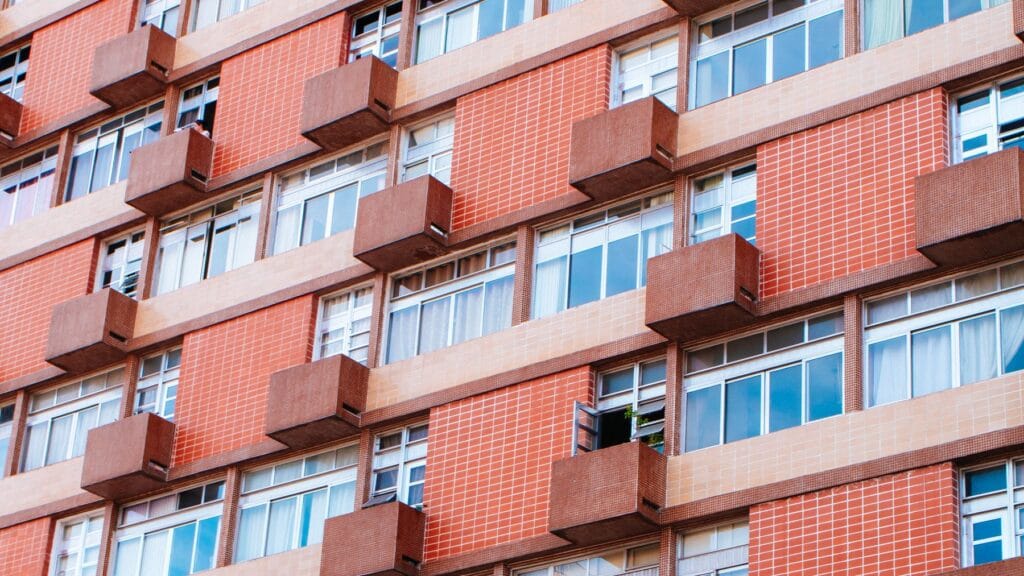 Balkonlu, kırmızı tuğla cepheli çok katlı apartman binası